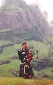 Highlander playing the pipes in a glen, shades of Brigadoon