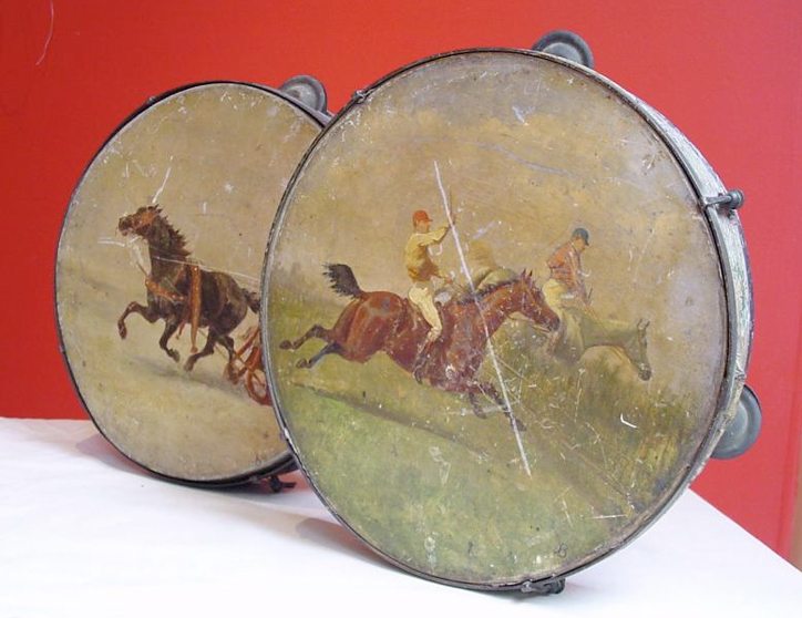 Two early illustrated tamborines. One painted with scenes from a Point-to-Point country horse race, the other of a prancing horse pulling a troika. These would make wonderful and unusual decorator items, or excellent additions to a collection courtesy Greengrass Antiques